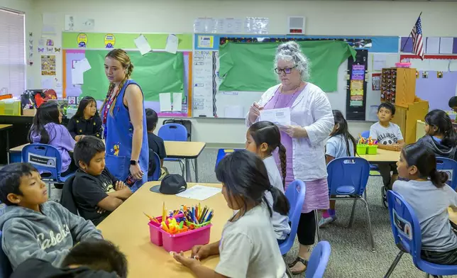 Third grade teachers Ciara Key, left, and Arden Serrato handing out tests, Tuesday, Oct. 1, 2024, at Algodones Elementary School in Algodones, N.M. (AP Photo/Roberto E. Rosales)