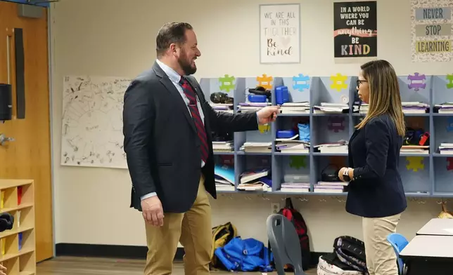 Principal Nicholas Ferro, left, talks with teacher Chirstine Monroid in her classroom at Rice Intermediate School Tuesday, Aug. 27, 2024, in San Carlos, Ariz. (AP Photo/Ross D. Franklin)