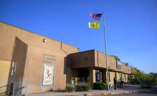 An American flag and New Mexico flag fly at Algodones Elementary School, Tuesday, Oct. 1, 2024, at Algodones Elementary School in Algodones, N.M. (AP Photo/Roberto E. Rosales)