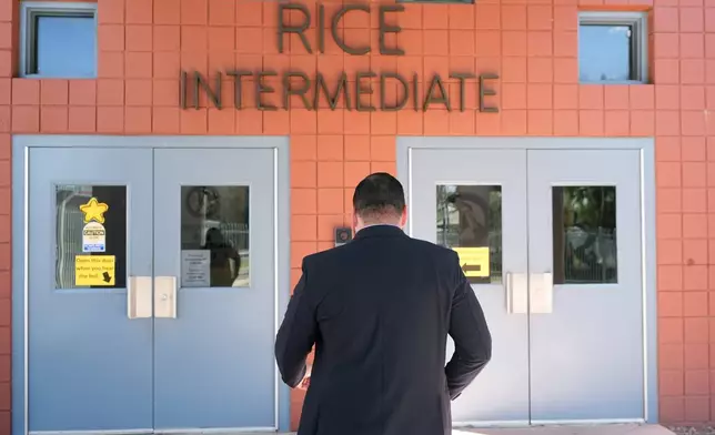 Rice Intermediate School Principal Nicholas Ferro walks to the main building on campus Tuesday, Aug. 27, 2024, in San Carlos, Ariz. (AP Photo/Ross D. Franklin)