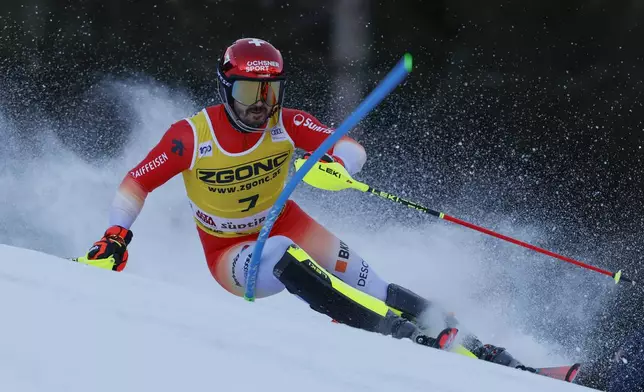 Switzerland's Loic Meillard speeds down the course during an alpine ski, men's World Cup slalom, in Alta Badia, Italy, Monday, Dec. 23, 2024. (AP Photo/Alessandro Trovati)