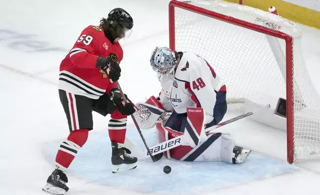 Washington Capitals goaltender Logan Thompson makes a save as Chicago Blackhawks' Tyler Bertuzzi looks for a rebound during the second period of an NHL hockey game Tuesday, Dec. 17, 2024, in Chicago. (AP Photo/Charles Rex Arbogast)