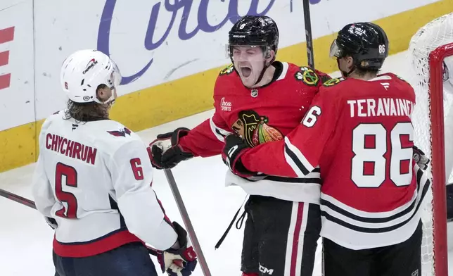 Chicago Blackhawks' Ryan Donato, center, celebrates his goal with Teuvo Teravainen as Washington Capitals' Jakob Chychrun watches during the third period of an NHL hockey game Tuesday, Dec. 17, 2024, in Chicago. (AP Photo/Charles Rex Arbogast)