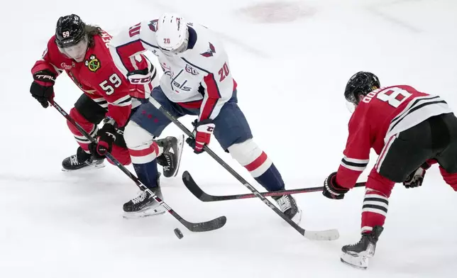 Chicago Blackhawks' Tyler Bertuzzi (59) Washington Capitals' Lars Eller (20) and Ryan Donato battles for a loose puck during the second period of an NHL hockey game Tuesday, Dec. 17, 2024, in Chicago. (AP Photo/Charles Rex Arbogast)