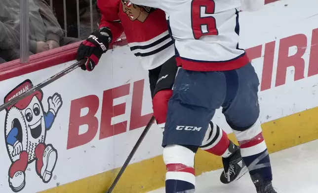 Washington Capitals' Jakob Chychrun (6) checks Chicago Blackhawks' Tyler Bertuzzi behind the net during the first period of an NHL hockey game Tuesday, Dec. 17, 2024, in Chicago. (AP Photo/Charles Rex Arbogast)