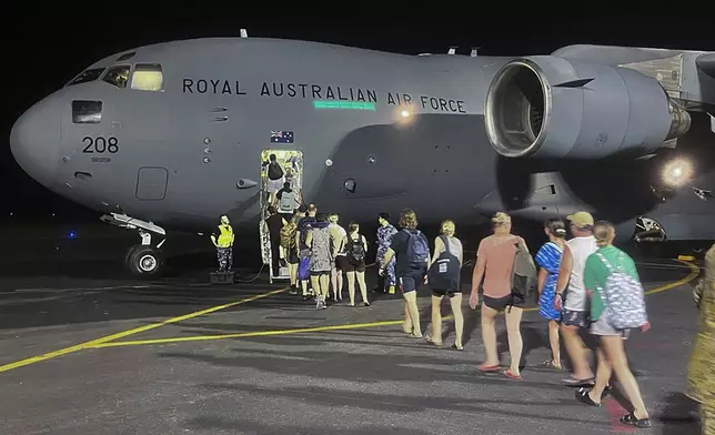 In this photo released by Australia's Department of Foreign Affairs and Trade (DFAT), Australians board a Royal Australian Air Force aircraft in Port Vila, Vanuatu in the early hours of Thursday, Dec. 19, 2024, following a powerful earthquake that struck just off the coast of Vanuatu in the South Pacific Ocean, Tuesday, Dec. 17, 2024. (DFAT via AP)