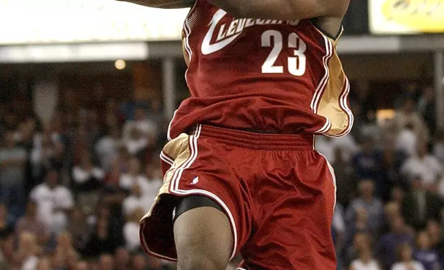 FILE - Cleveland Cavaliers guard LeBron James passes the ball off as he drives the lane against the Sacramento Kings during the second half at Arco Arena in Sacramento, Calif., on Oct. 29, 2003. (AP Photo/Steve Yeater, File)