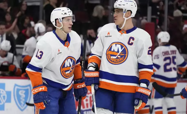 New York Islanders center Mathew Barzal, left, talks with left wing Anders Lee, right, during the second period of an NHL hockey game against the Chicago Blackhawks in Chicago, Sunday, Dec. 15, 2024. (AP Photo/Nam Y. Huh)