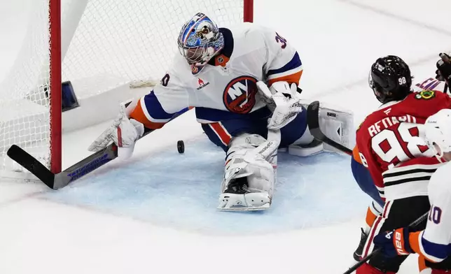 New York Islanders goaltender Ilya Sorokin, left, cannot stop a goal by Chicago Blackhawks center Connor Bedard (98) during the third period of an NHL hockey game in Chicago, Sunday, Dec. 15, 2024. (AP Photo/Nam Y. Huh)