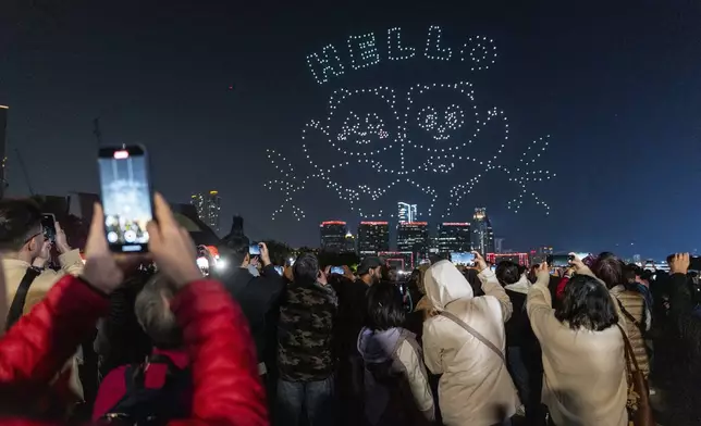 People watch the panda-themed drone show at the waterfront of the Victoria Harbour in Hong Kong, Saturday, Dec. 28, 2024. (AP Photo/Chan Long Hei)