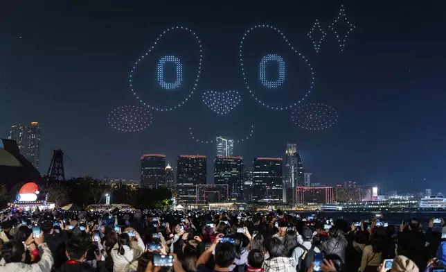 People watch the panda-themed drone show at the waterfront of the Victoria Harbour in Hong Kong, Saturday, Dec. 28, 2024. (AP Photo/Chan Long Hei)