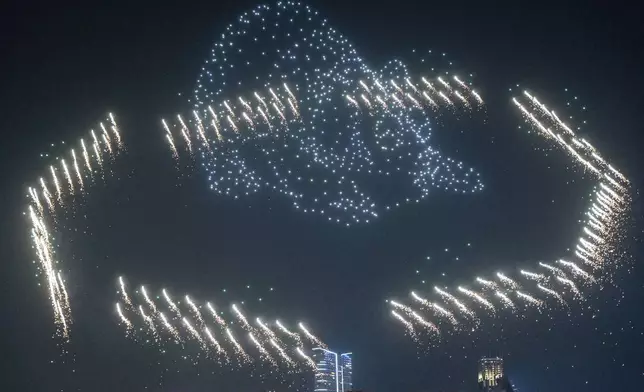 People watch the panda-themed drone show at the waterfront of the Victoria Harbour in Hong Kong, Saturday, Dec. 28, 2024. (AP Photo/Chan Long Hei)