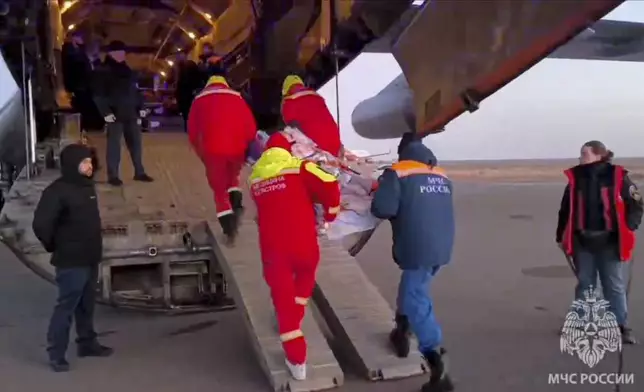 In this image released by the Russian Emergency Ministry Press Service, rescuers carry a wounded passenger near the Kazakhstani city of Aktau, Thursday, Dec. 26 , 2024, after a plane of Azerbaijani Airline crashed. (Russian Emergency Ministry Press Service via AP)