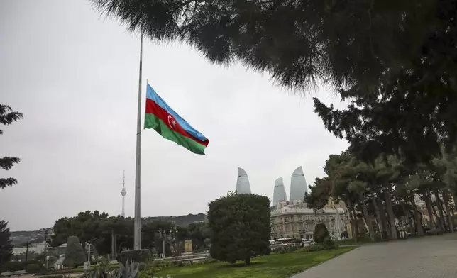 Azerbaijan's national flag at half-mast in the memory of victims of the Azerbaijan Airlines' Embraer 190 that crashed near the Kazakhstan's airport of Aktau, is seen in the center of Baku, Azerbaijan, Thursday, Dec. 26, 2024. (AP Photo/Aziz Karimov)