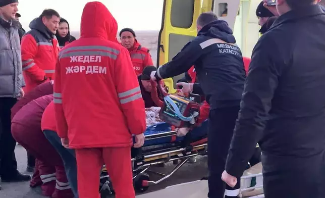 In this photo taken from a video released by the administration of Mangystau region, rescuers prepare to carry a wounded passenger near the Kazakhstani city of Aktau, Thursday, Dec. 26 , 2024, after a plane of Azerbaijani Airline crashed. (The Administration of Mangystau Region via AP)