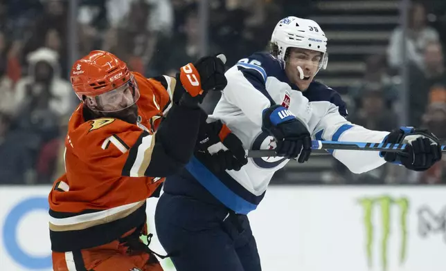 Anaheim Ducks defenseman Radko Gudas (7) checks Winnipeg Jets center Morgan Barron (36) during the second period of an NHL hockey game, Wednesday, Dec. 18, 2024, in Anaheim, Calif. (AP Photo/Kyusung Gong)