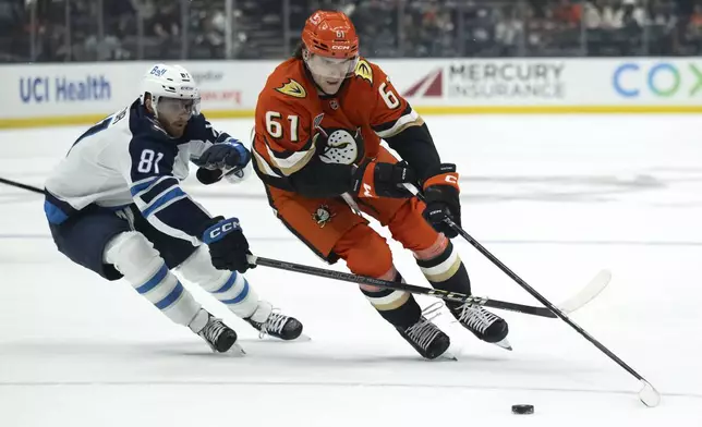 Anaheim Ducks left wing Cutter Gauthier (61) controls he puck over Winnipeg Jets left wing Kyle Connor (81) during the first period of an NHL hockey game, Wednesday, Dec. 18, 2024, in Anaheim, Calif. (AP Photo/Kyusung Gong)