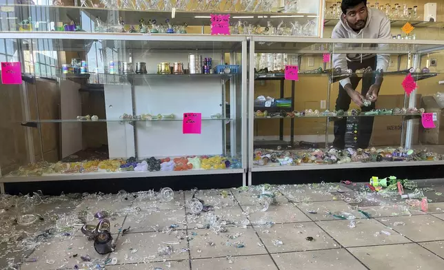 Hasan Raza cleans up in the aftermath of a 7.0 earthquake inside E&amp;J Liquors, Thursday, Dec. 5, 2024, in Rio Dell, Calif. (Savana Robinson via AP)