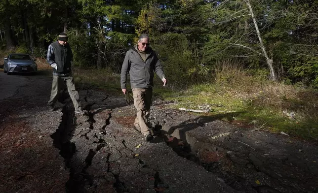 California Geological Survey engineering geologists John Oswald, right, and Spencer Watkins assess damage to a road following a 7.0 earthquake Friday, Dec. 6, 2024, in Humboldt County, Calif. (AP Photo/Godofredo A. Vásquez)