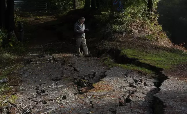 California Geological Survey senior engineering geologist John Oswald, right, assesses damage to a road following a 7.0 earthquake Friday, Dec. 6, 2024, in Humboldt County, Calif. (AP Photo/Godofredo A. Vásquez)