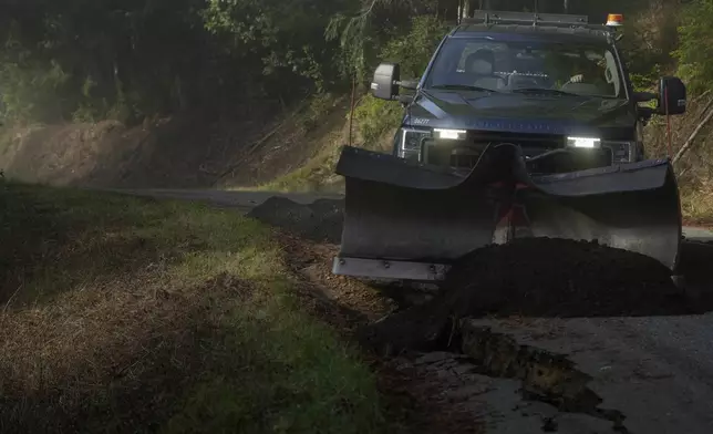 Humboldt County road maintenance supervisor Wayne Tomasini fills in cracks with dirt on a road damaged by a 7.0 earthquake in Humboldt County, Calif., Friday, Dec. 6, 2024. (AP Photo/Godofredo A. Vásquez)