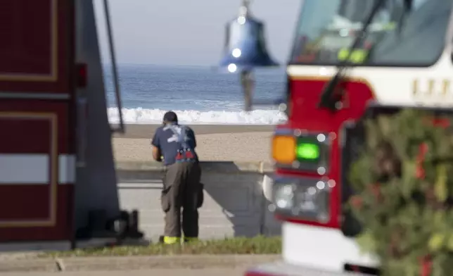 A firefighter patrols Ocean Beach in San Francisco during a tsunami warning on Thursday, Dec. 5, 2024. (AP Photo/Emily Steinberger)