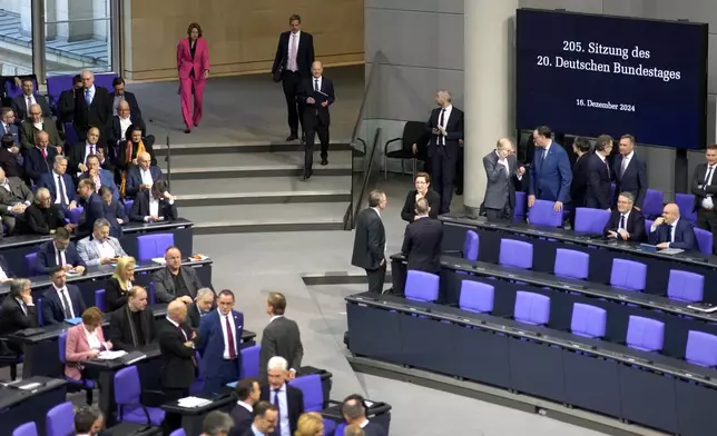 German Chancellor Olaf Scholz, centre arrives for a plenary session at the German parliament Bundestag where he faces a vote of confidence, Berlin, Germany, Monday, Dec. 16, 2024. (AP Photo/Markus Schreiber)