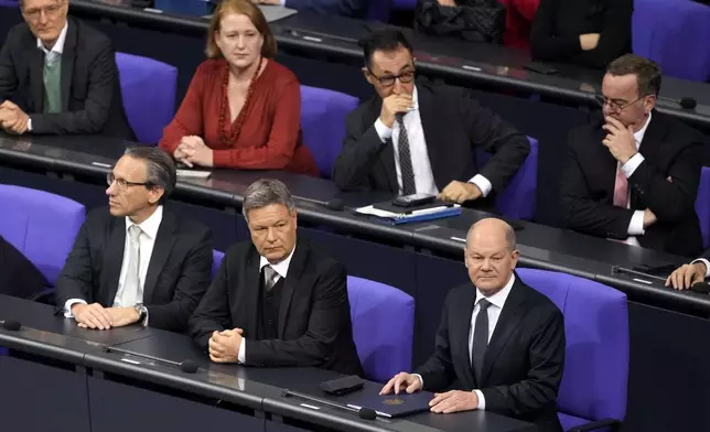 German Chancellor Olaf Scholz,, bottom right, attends a plenary session at the German parliament Bundestag where he faces a vote of confidence, Berlin, Germany, Monday, Dec. 16, 2024. (AP Photo/Markus Schreiber)