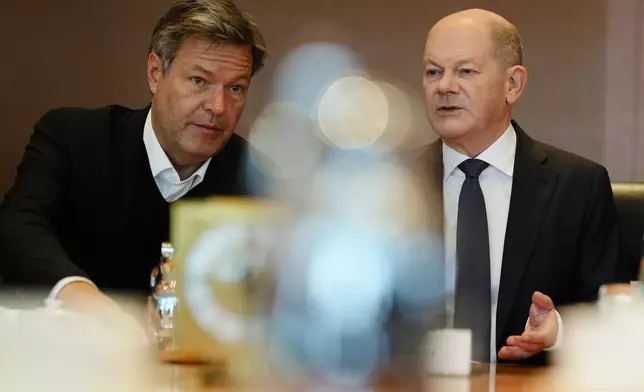 German Chancellor Olaf Scholz, right, speaks with Vice Chancellor and Economy and Climate Minister Robert Habeck, left, during the cabinet meeting at the chancellery in Berlin, Germany, Wednesday, Dec. 11, 2024. (AP Photo/Markus Schreiber)