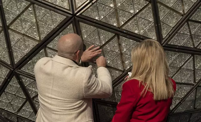 Singer Pitbull, left, and Joy Mangano, right, founder of CleanBoss, install a crystal during the Times Square New Year's Eve Ball Crystal Installation at One Times Square, Friday, Dec. 27, 2024, in New York. (AP Photo/Yuki Iwamura)