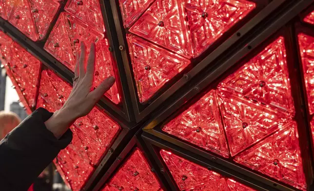 A person touches the Times Square New Year's Eve Ball at One Times Square, Friday, Dec. 27, 2024, in New York. (AP Photo/Yuki Iwamura)