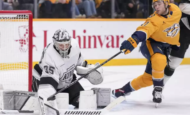 Los Angeles Kings goaltender Darcy Kuemper (35) blocks a shot on goal by Nashville Predators center Mark Jankowski, right, during the second period of an NHL hockey game Saturday, Dec. 21, 2024, in Nashville, Tenn. (AP Photo/George Walker IV)