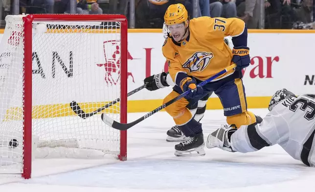 Nashville Predators defenseman Nick Blankenburg (37) scores the game winning goal past Los Angeles Kings goaltender Darcy Kuemper (35) in overtime of an NHL hockey game Saturday, Dec. 21, 2024, in Nashville, Tenn. The Predators won 3-2. (AP Photo/George Walker IV)