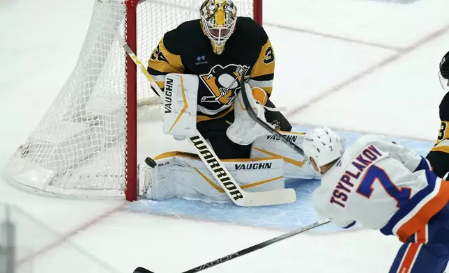 Pittsburgh Penguins goaltender Alex Nedeljkovic stops a shot by New York Islanders' Maxim Tsyplakov (7) during the first period of an NHL hockey game, Sunday, Dec. 29, 2024, in Pittsburgh. (AP Photo/Matt Freed)