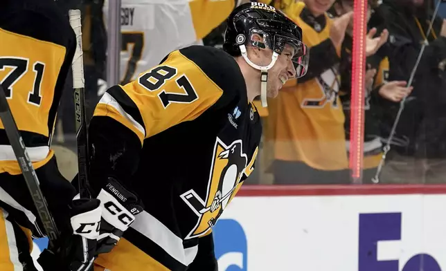 Pittsburgh Penguins' Sidney Crosby (87) celebrates after surpassing Mario Lemieux for the team's all-time leader in assists on a goal by Michael Bunting during the second period of an NHL hockey game against the New York Islanders, Sunday, Dec. 29, 2024, in Pittsburgh. (AP Photo/Matt Freed)