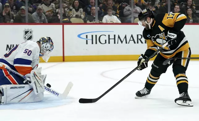 New York Islanders goaltender Marcus Hogberg (50) makes a save against Pittsburgh Penguins' Bryan Rust (17) during the second period of an NHL hockey game Sunday, Dec. 29, 2024, in Pittsburgh. (AP Photo/Matt Freed)