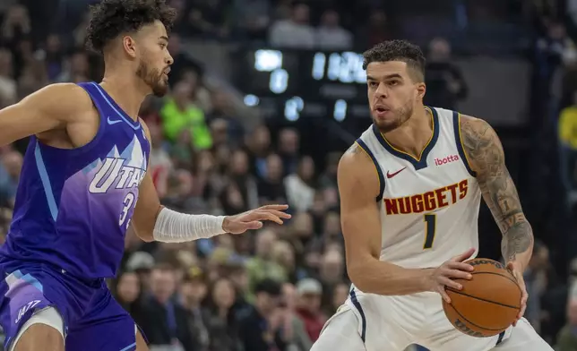 Denver Nuggets forward Michael Porter Jr. (1) looks to shoot as Utah Jazz guard Johnny Juzang, left, defends during the first half of an NBA basketball game Monday, Dec. 30, 2024, in Salt Lake City. (AP Photo/Rick Egan)