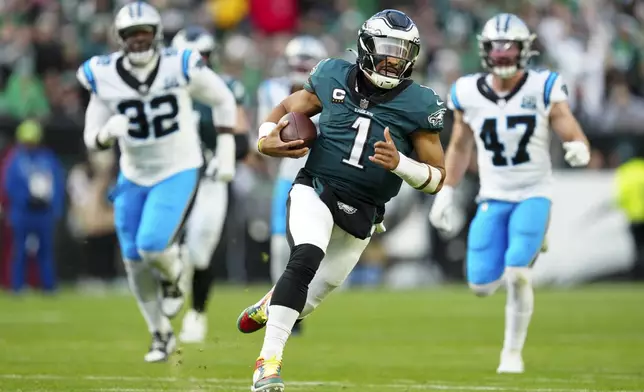 Philadelphia Eagles quarterback Jalen Hurts (1) runs with the ball as Carolina Panthers cornerback Lonnie Johnson Jr. (32) and linebacker Josey Jewell (47) trail behind during the second half of an NFL football game Sunday, Dec. 8, 2024, in Philadelphia. (AP Photo/Derik Hamilton)