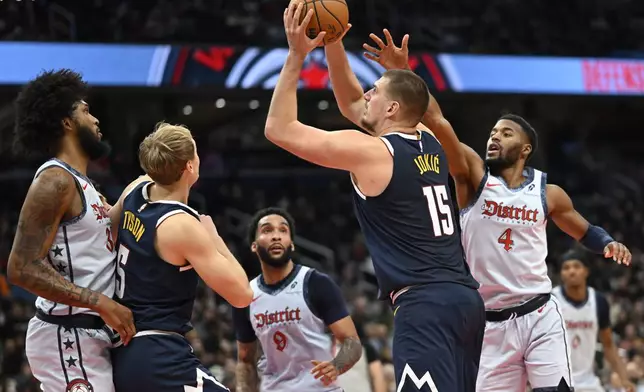 Denver Nuggets center Nikola Jokic (15)looks to score a basket past Washington Wizards guard Jared Butler (4) during the second half of an NBA basketball game Saturday, Dec. 7, 2024, in Washington. (AP Photo/John McDonnell)
