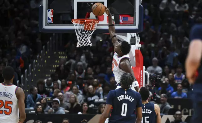 New York Knicks forward OG Anunoby (8) dunks the ball during the first half of an NBA basketball game against the Washington Wizards, Saturday, Dec. 28, 2024, in Washington. (AP Photo/Terrance Williams)