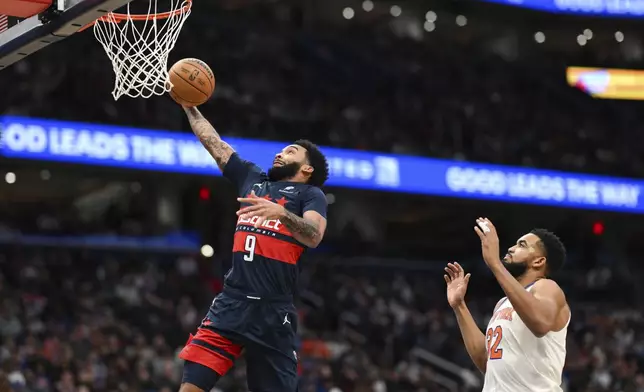 Washington Wizards forward Justin Champagnie (9) dunks the ball as New York Knicks center Karl-Anthony Towns trails during the first half of an NBA basketball game, Saturday, Dec. 28, 2024, in Washington. (AP Photo/Terrance Williams)