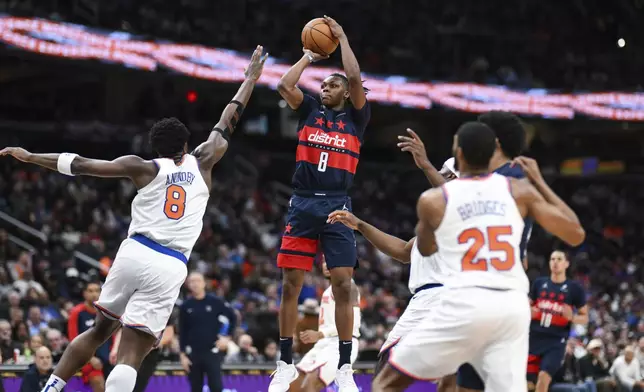 Washington Wizards guard Carlton Carrington (8) shoots the ball as New York Knicks forward OG Anunoby (8) defends during the first half of an NBA basketball game, Saturday, Dec. 28, 2024, in Washington. (AP Photo/Terrance Williams)