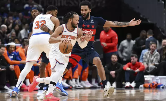 New York Knicks guard Jalen Brunson handles the ball against Washington Wizards forward Justin Champagnie during the first half of an NBA basketball game, Saturday, Dec. 28, 2024, in Washington. (AP Photo/Terrance Williams)