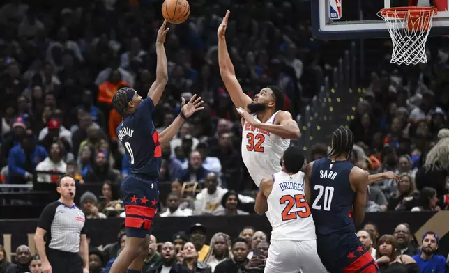 Washington Wizards guard Bilal Coulibaly (0) shoots the ball over New York Knicks center Karl-Anthony Towns (32) during the second half of an NBA basketball game, Saturday, Dec. 28, 2024, in Washington. (AP Photo/Terrance Williams)