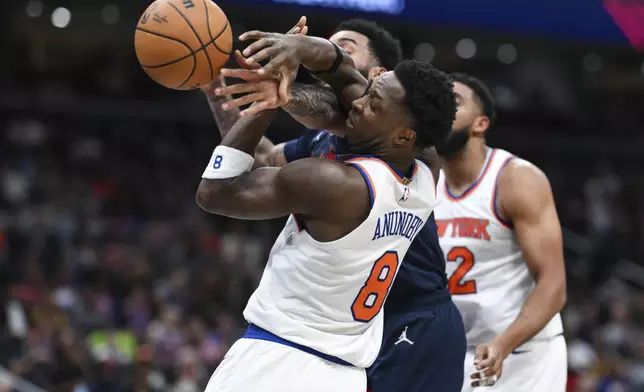 New York Knicks forward OG Anunoby (8) competes for the ball against Washington Wizards forward Justin Champagnie, back left, during the first half of an NBA basketball game, Saturday, Dec. 28, 2024, in Washington. (AP Photo/Terrance Williams)