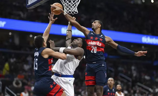 New York Knicks forward OG Anunoby (8) has his shot blocked by Washington Wizards forward Alexandre Sarr (20) during the second half of an NBA basketball game, Saturday, Dec. 28, 2024, in Washington. (AP Photo/Terrance Williams)