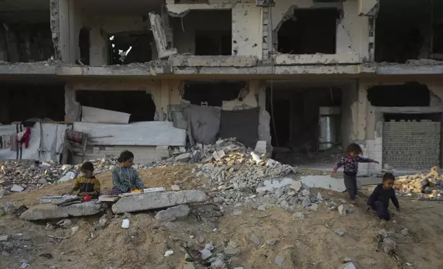 Palestinian children play on the rubble of destroyed buildings at a neighbourhood in Khan Younis, Gaza Strip, Sunday, Dec. 1, 2024. (AP Photo/Abdel Kareem Hana)