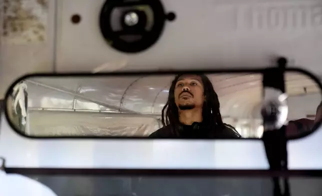 Nate Debos, known by his stage name NaTRILL Dizaster, who said he would apply for Benin citizenship, poses inside an old school bus in New Orleans, Thursday, Dec. 5, 2024. (AP Photo/Gerald Herbert)