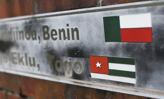 FILE - In this Jan. 29, 2019 file photo, the flags of the nations of Benin and Togo, the west African homes of the survivors of the slave ship Clotilda, remain on display on a monument at what was the Africatown Welcome Center in Mobile, Ala. (AP Photo/Julie Bennett, File)