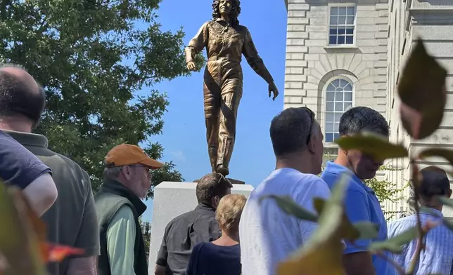 A crowd surrounds the newly-unveiled statue of Christa McAuliffe, NASA's first teacher in space, outside the Statehouse, Monday, Sept. 2, 2024, in Concord, N.H. (AP Photo/Holly Ramer, File)